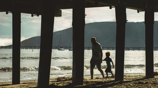 parent and child walking beach